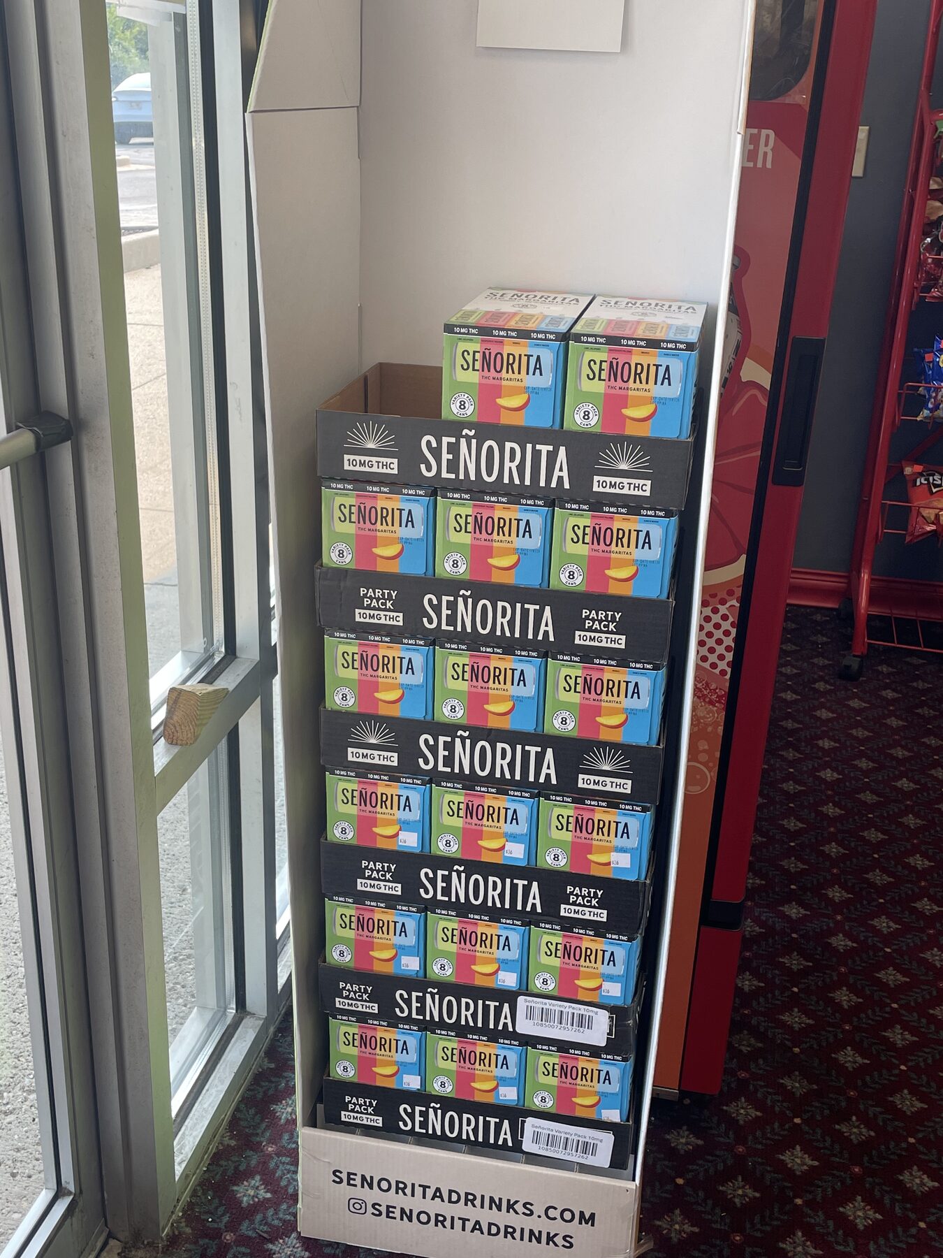 Colorful Señorita beverage packages stacked beside a window