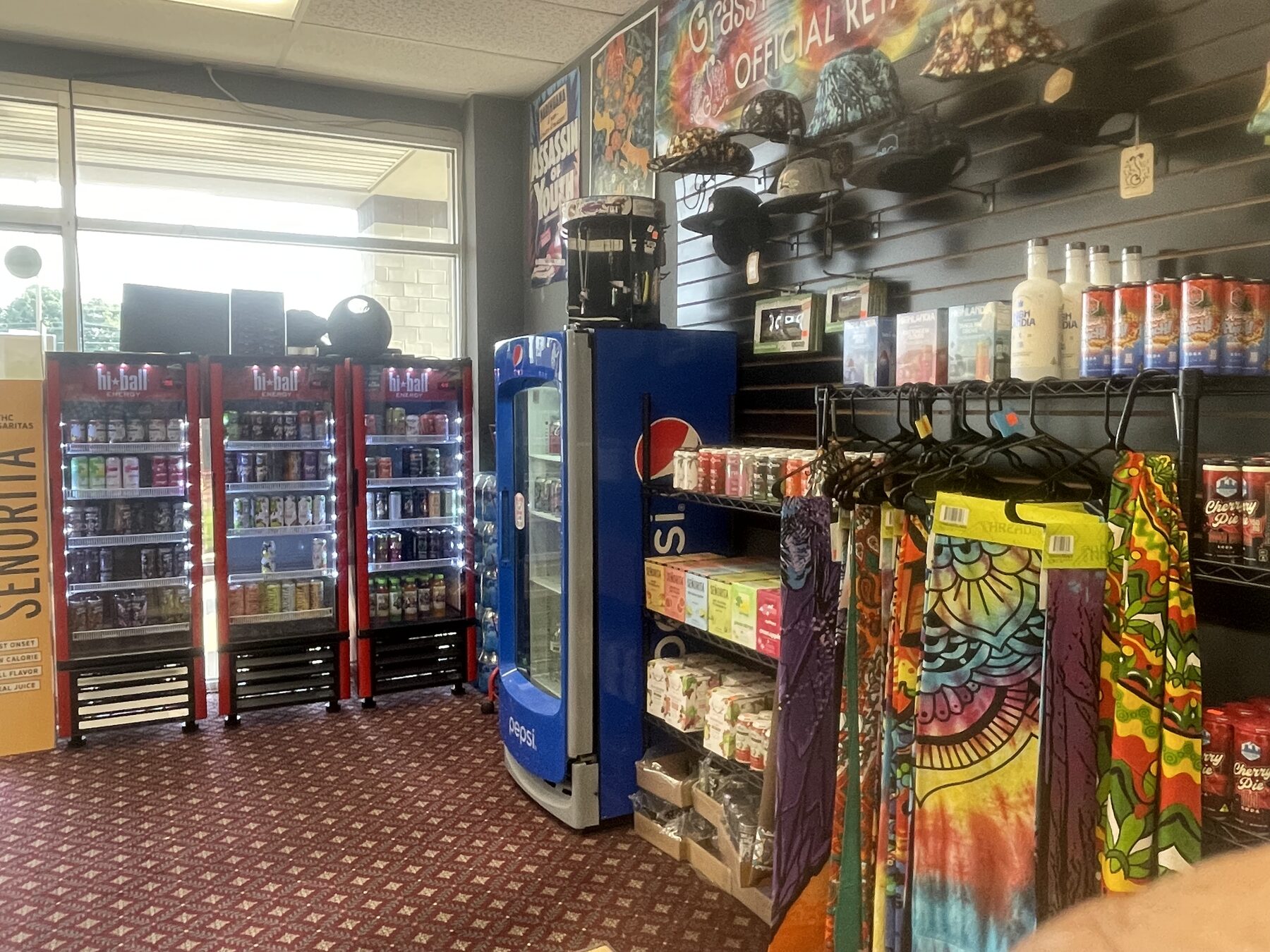 Shop entrance with beverage coolers, apparel, and wall displays